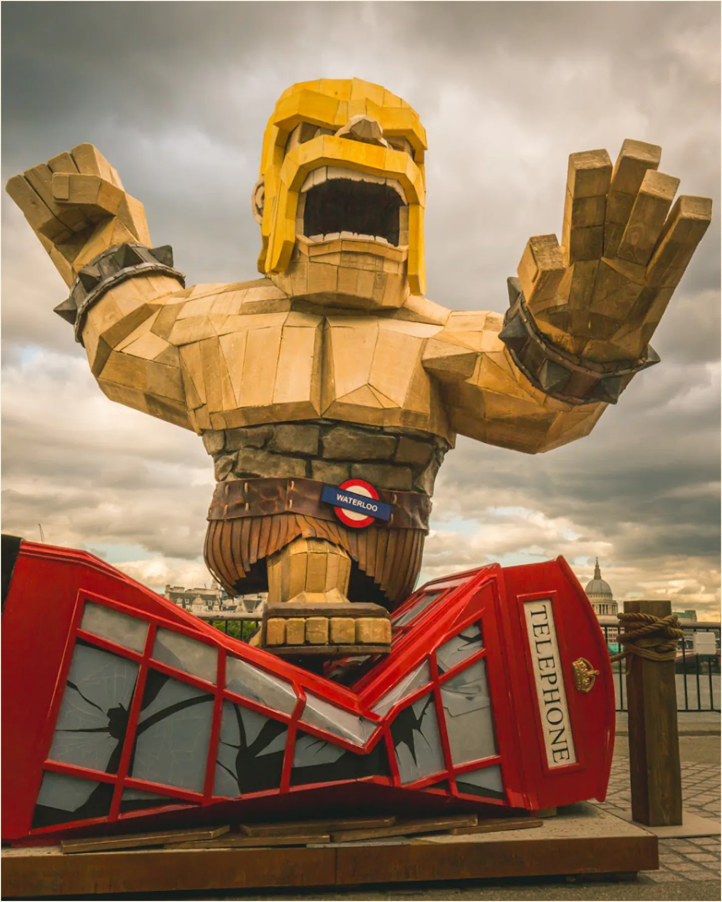 Giant wooden figure bursting through a London phone box for a PR stunt